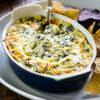 cheesy spinach dip with a serving spoon