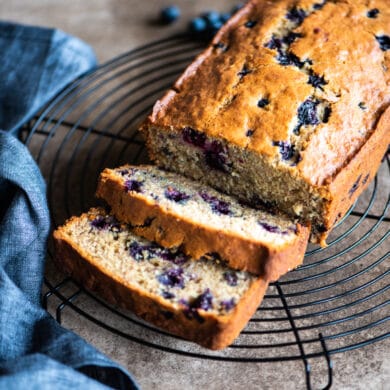 sliced blueberry banana bread on a cooling rack