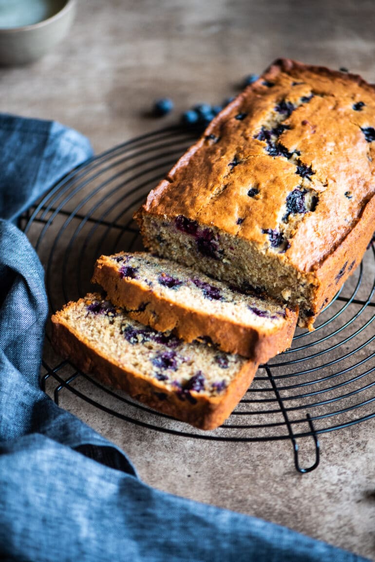 sliced blueberry banana bread on a cooling rack