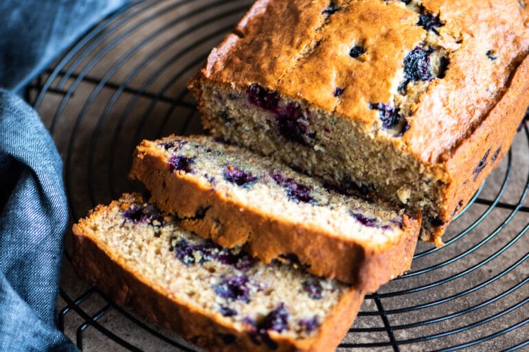 sliced blueberry banana bread on a cooling rack