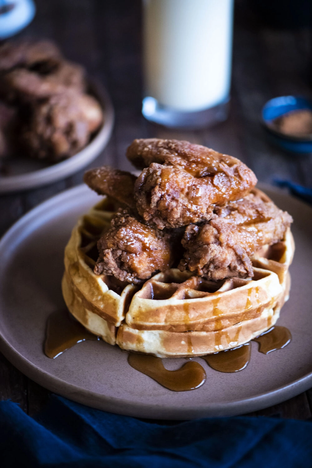 closeup of chicken and waffles on table with cup of eggnog