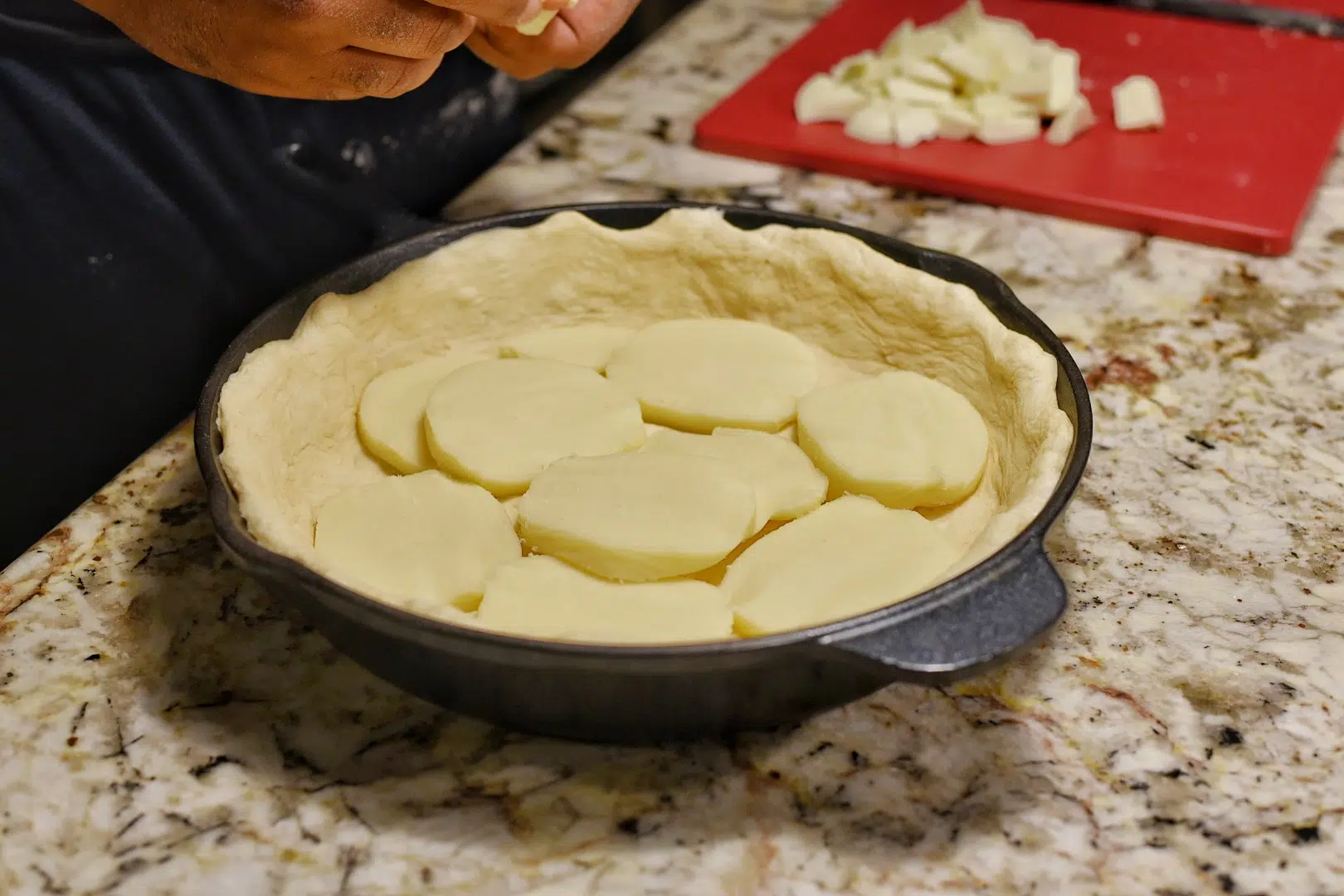 Layering the first layer of thick slices of mozzarella to the pizza