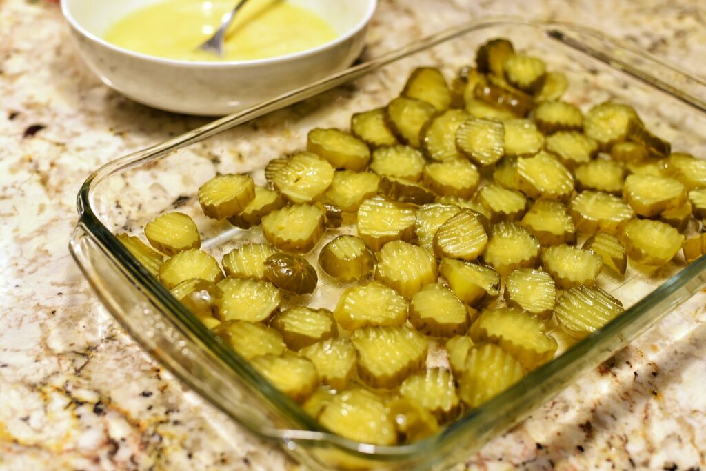 Sliced pickles in a glass baking dish