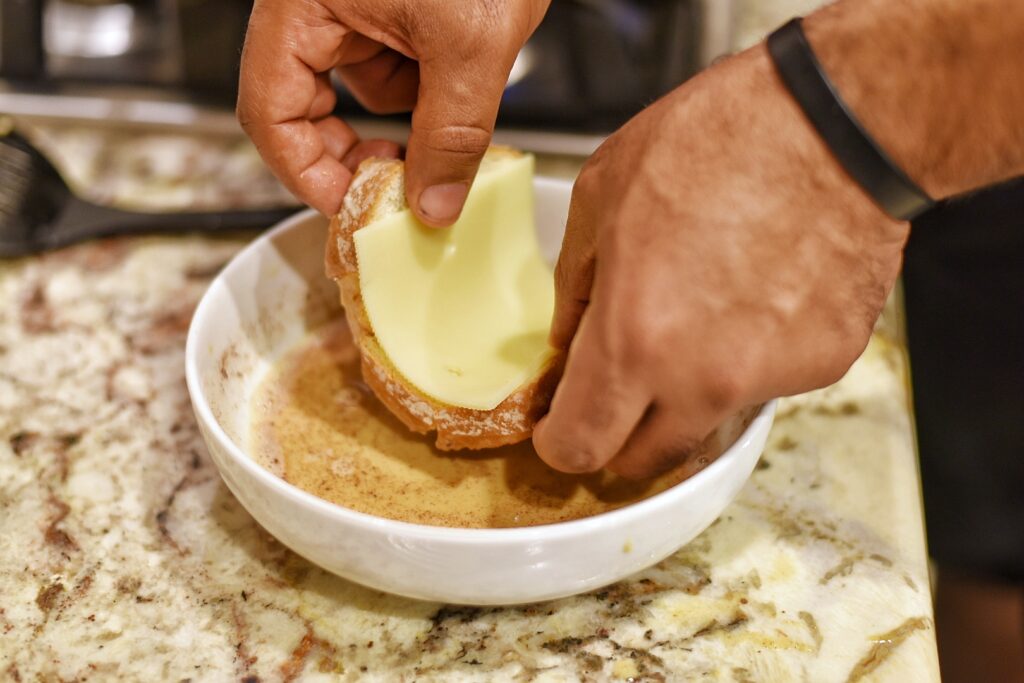 Dipping one side of bread into egg mixture