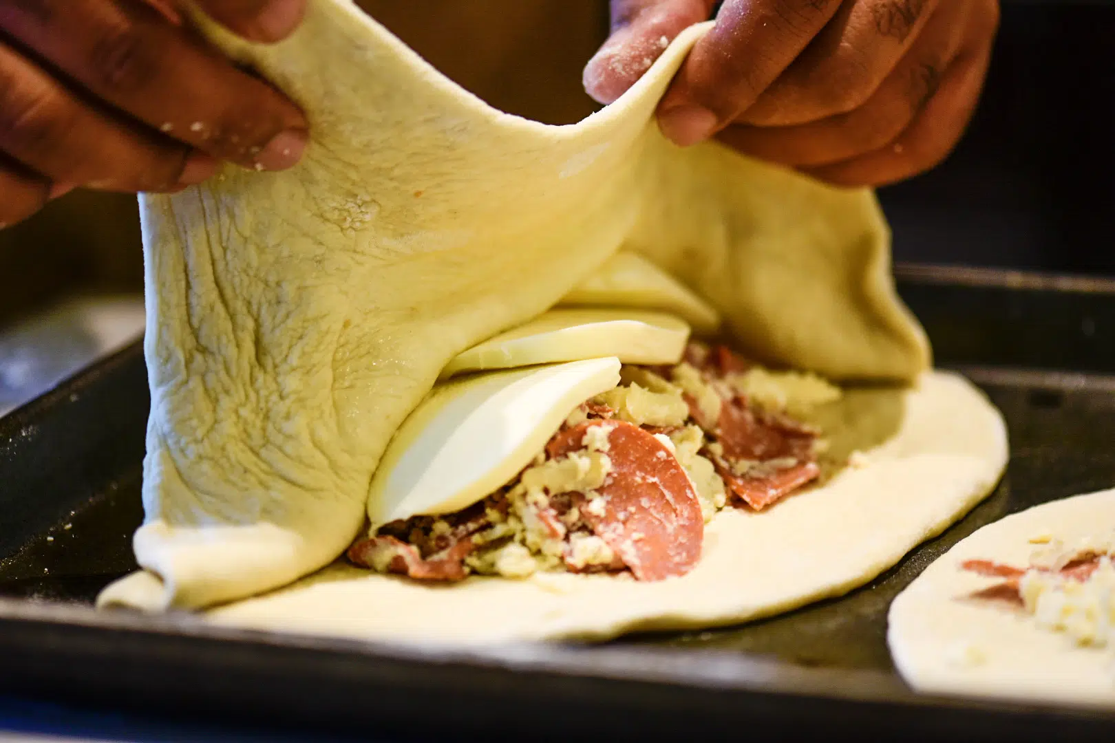 Folding the fresh dough over the stuffed ingredients