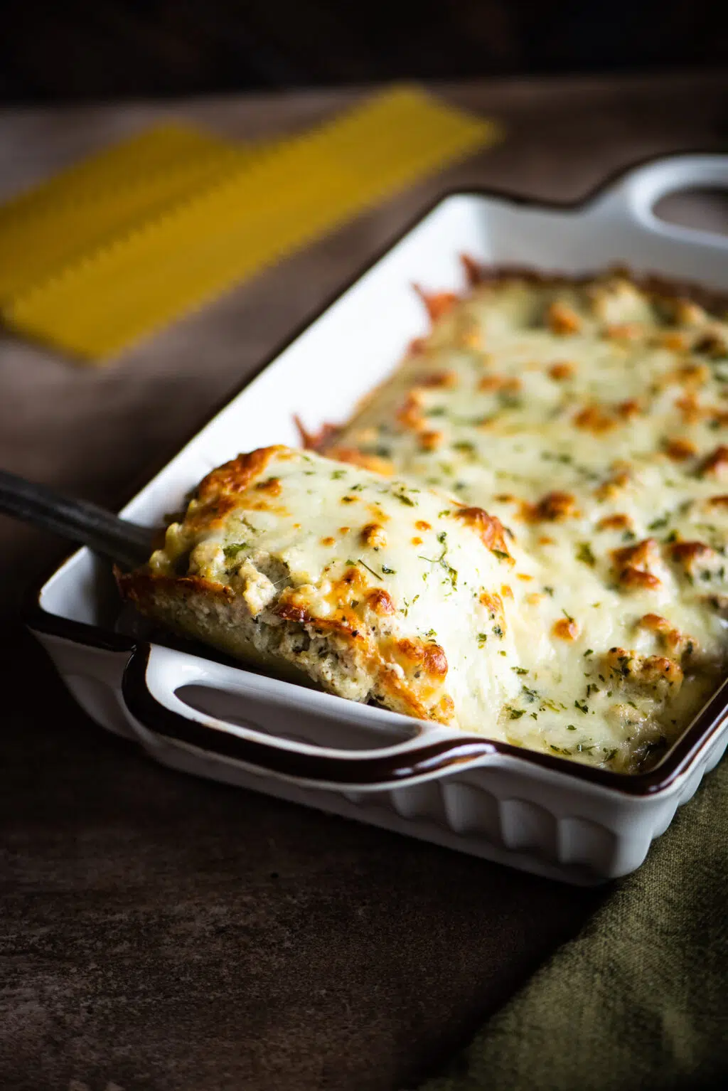 Taking a lasagna roll from the baking dish