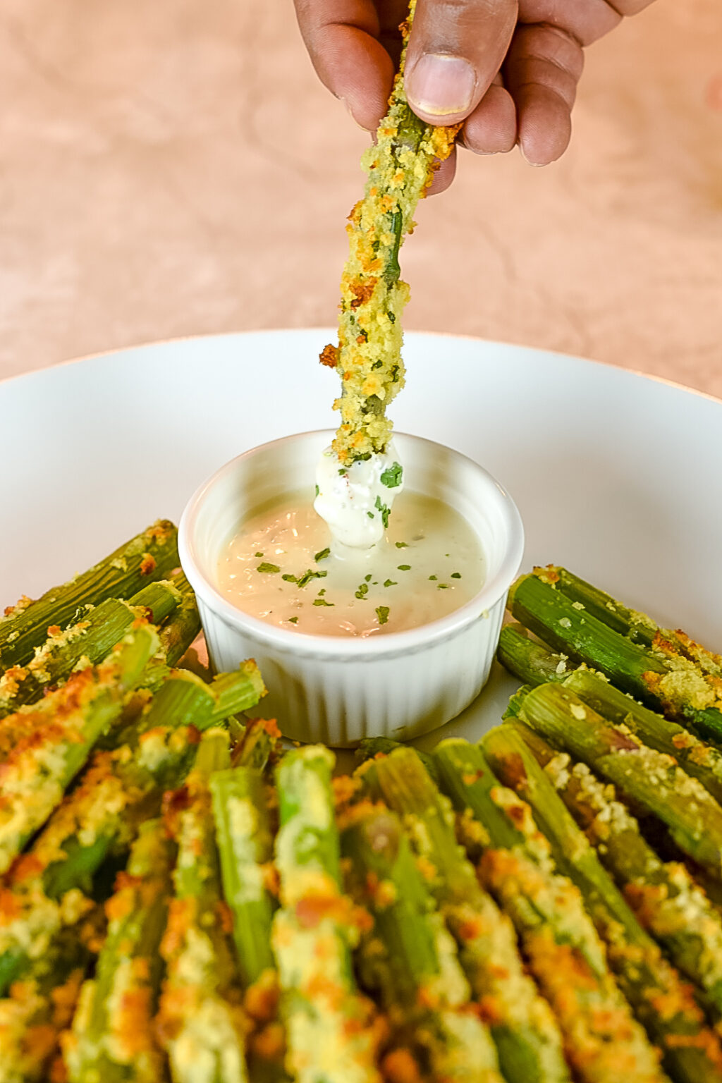 Dipping Parmesan Crusted Asparagus Spears in ranch dressing.