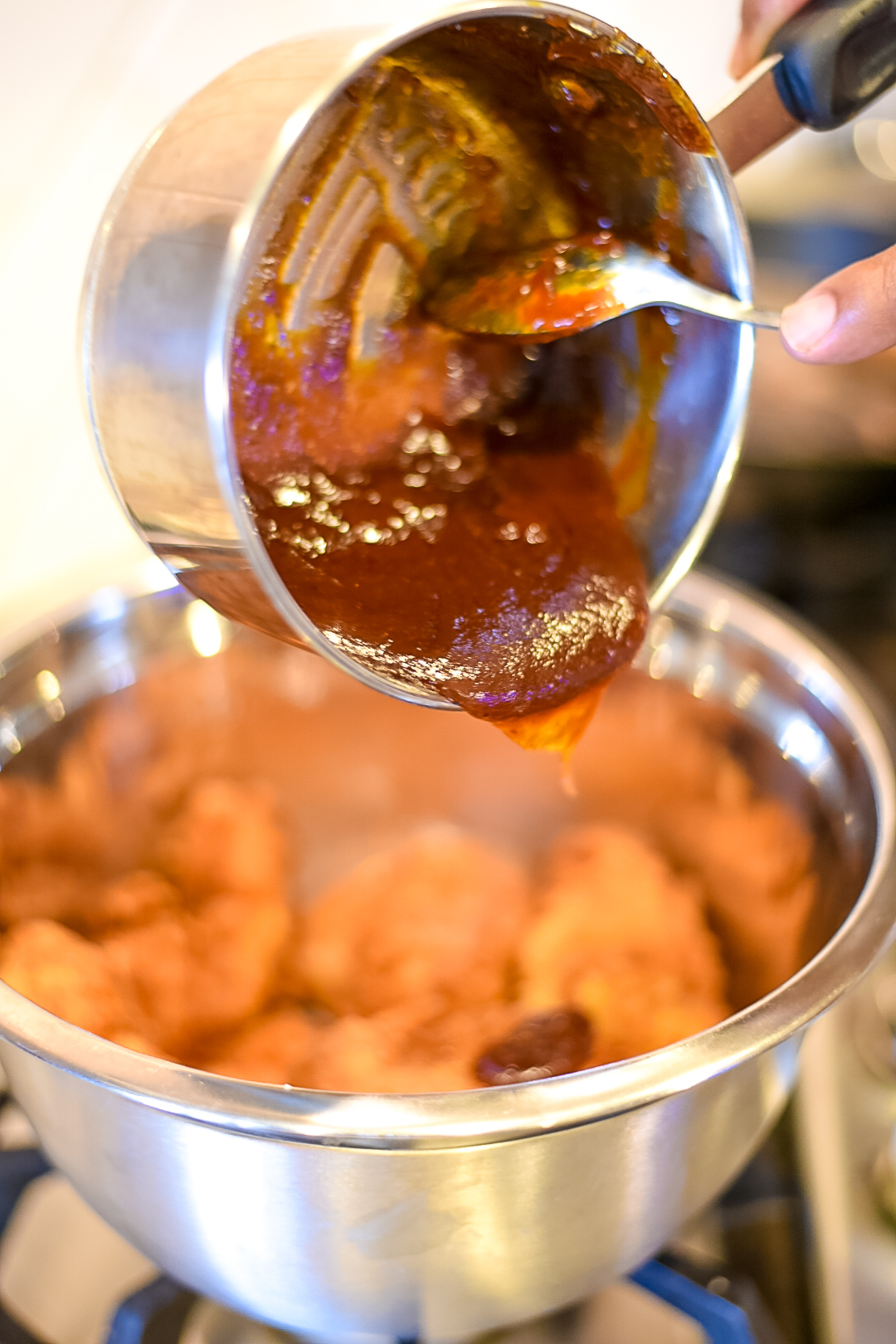 Pouring the BBQ over the crispy chicken strips