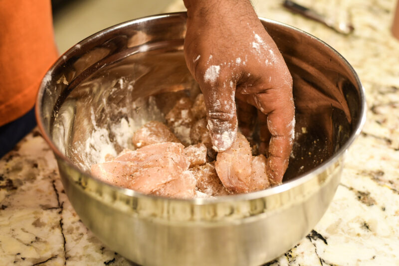 Adding flour to red snapper before frying