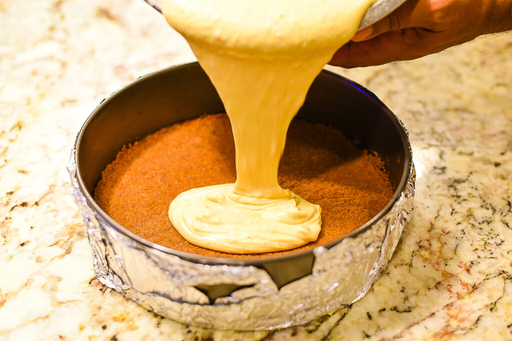 Pouring in the sweet potato cheesecake filling