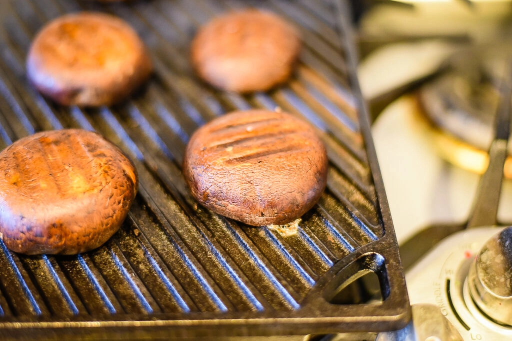 Grilling the portobello mushrooms on a cast iron grill