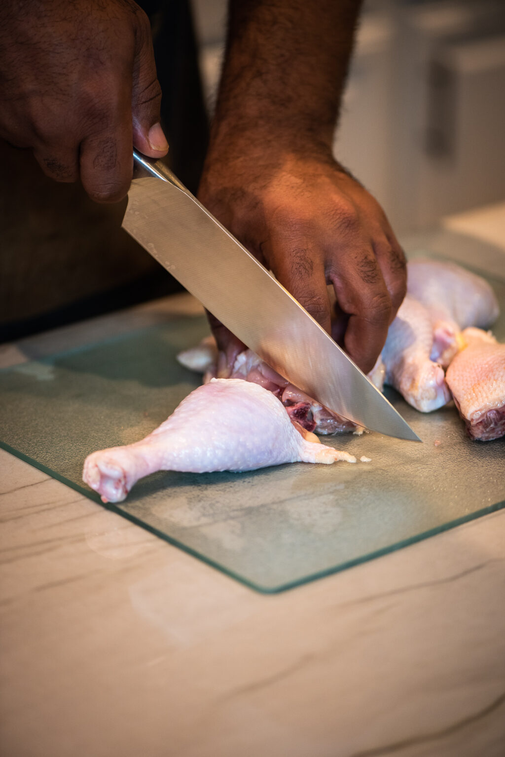 using chef's knife to cut chicken leg quarters