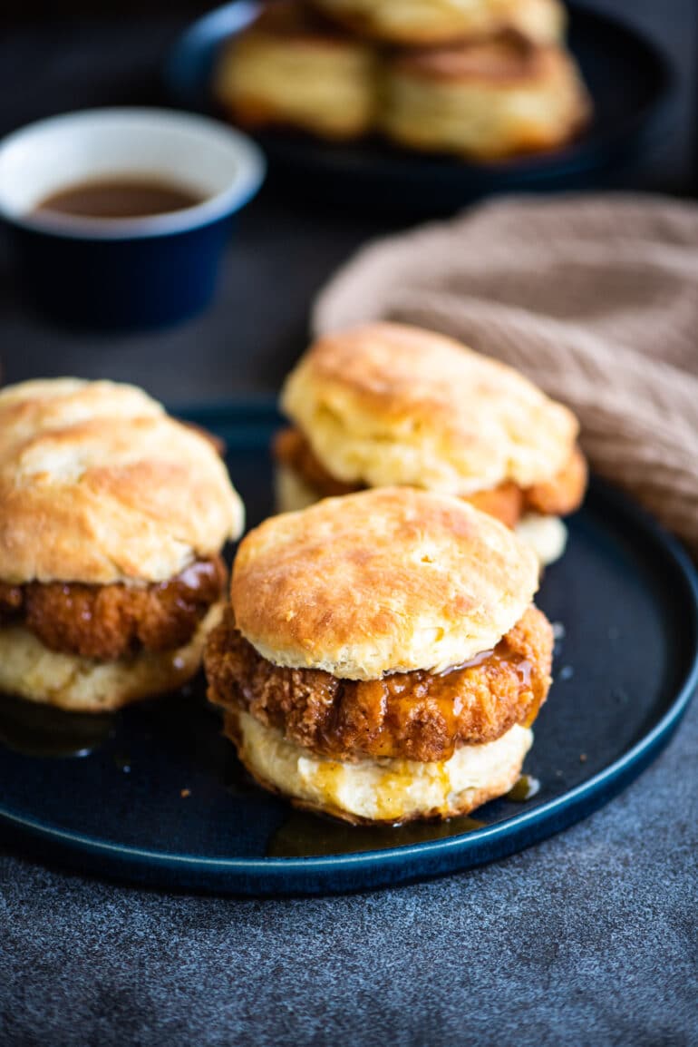 Three chicken biscuits on a large blue plate