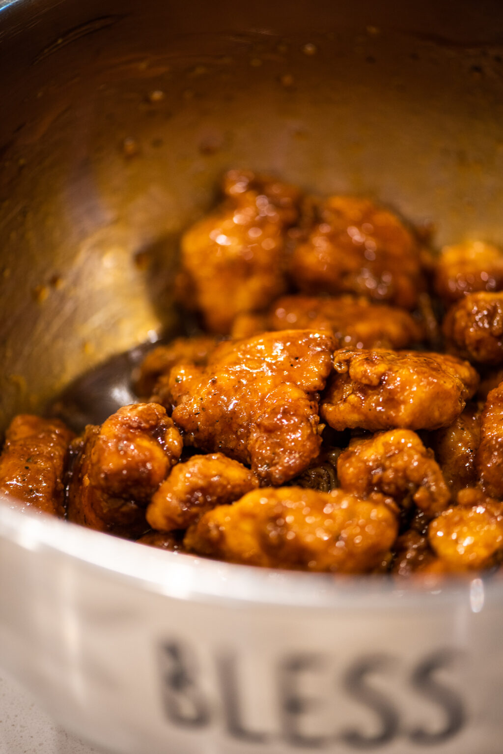 tossing fried chicken nuggets in homemade teriyaki sauce