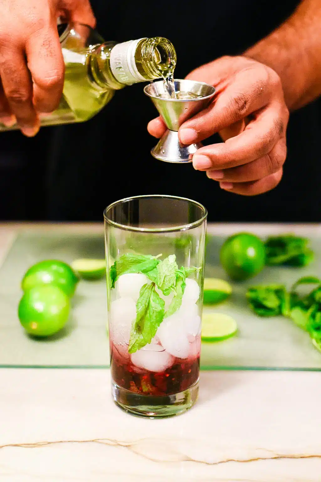 adding vodka the make a blackberry mojito cocktail