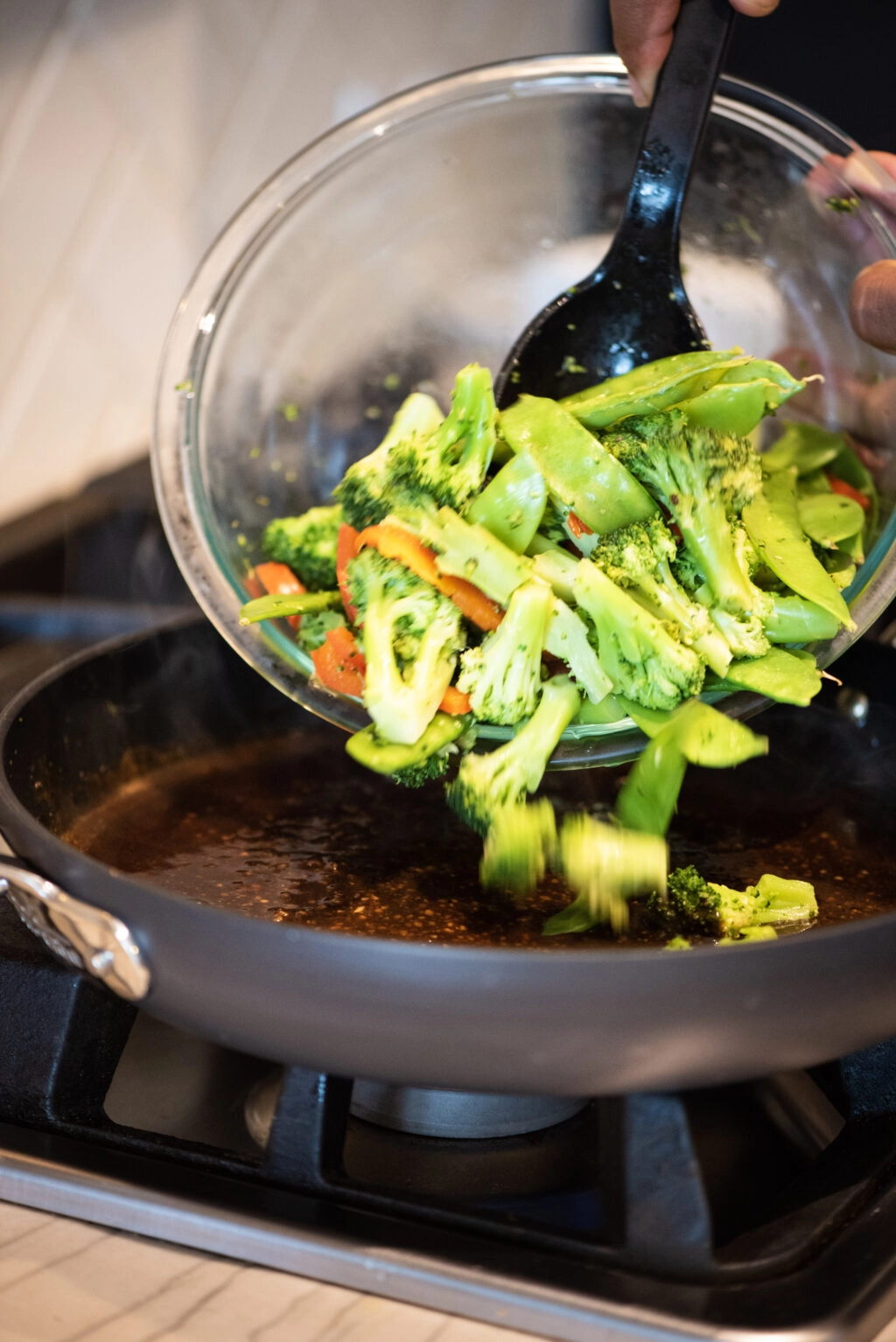 Adding fresh vegetables to pan