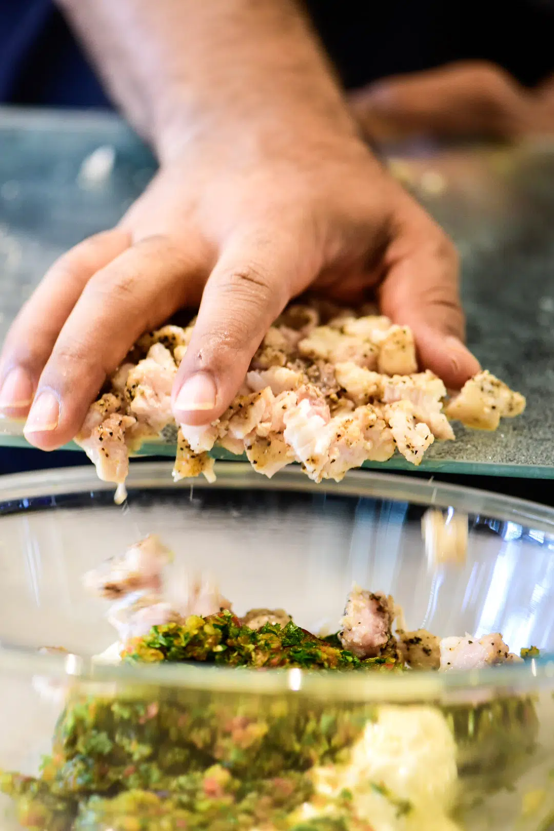 Adding chopped red snapper to bowl of ingredients