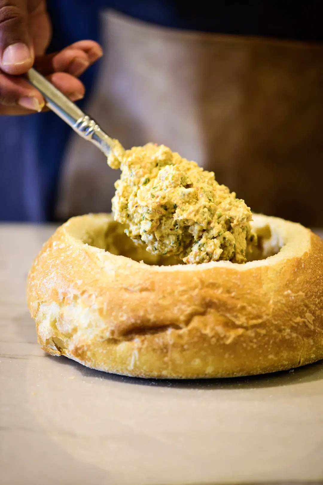 Adding fish dip to bread bowl