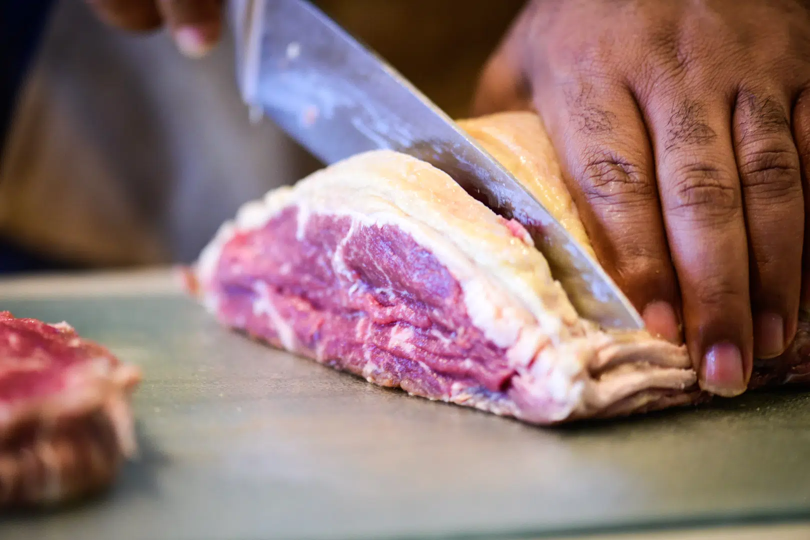 Cutting 8 oz. portions of strip loin