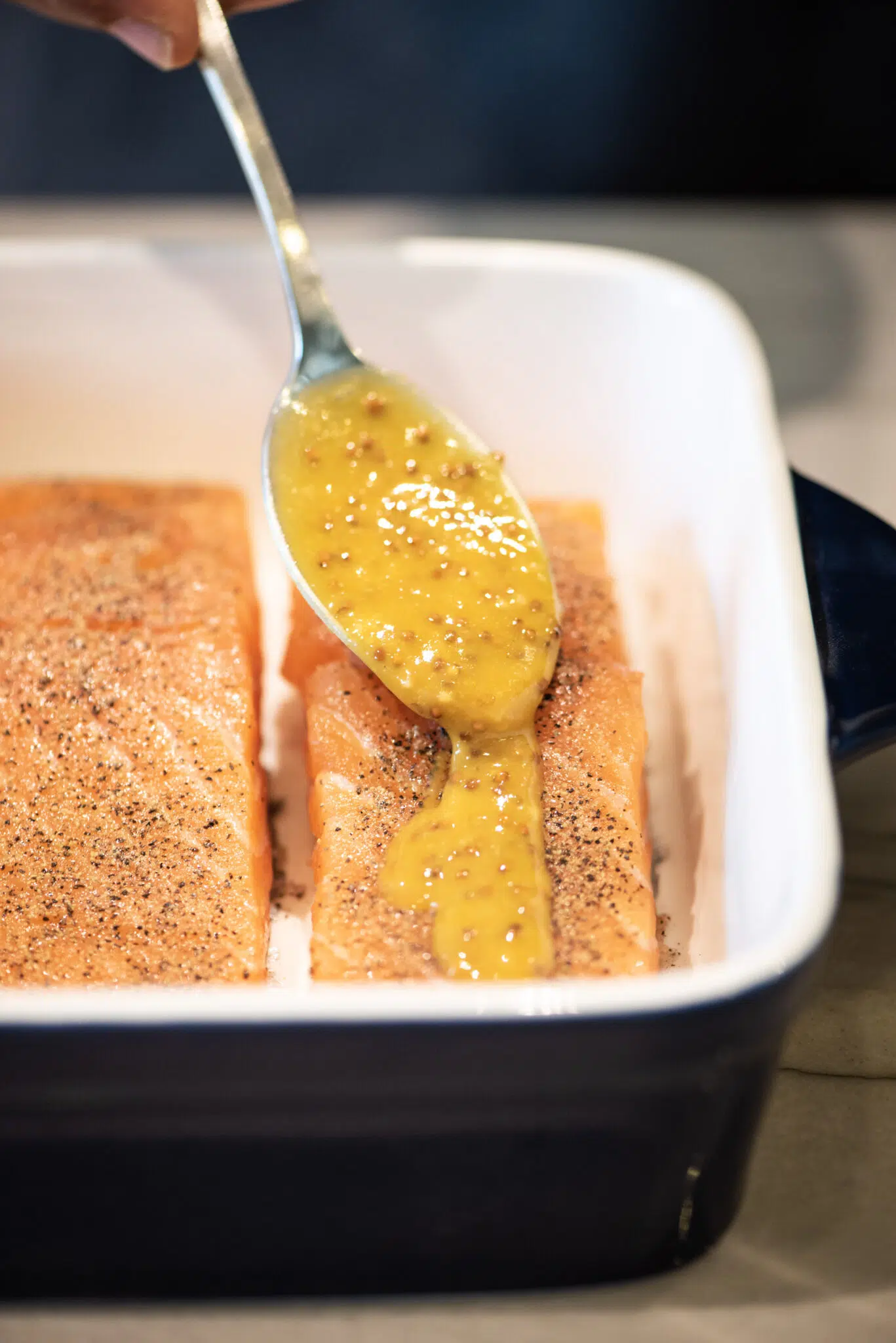 Adding honey-mustard glaze to salmon