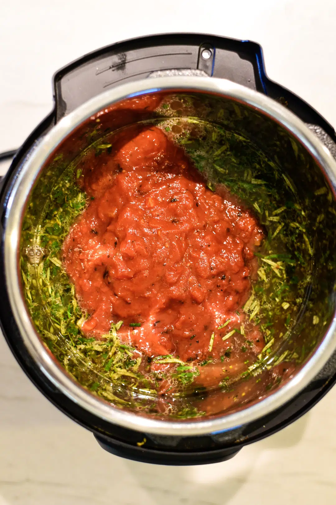 Adding crushed fire-roasted tomatoes to the Instant Pot