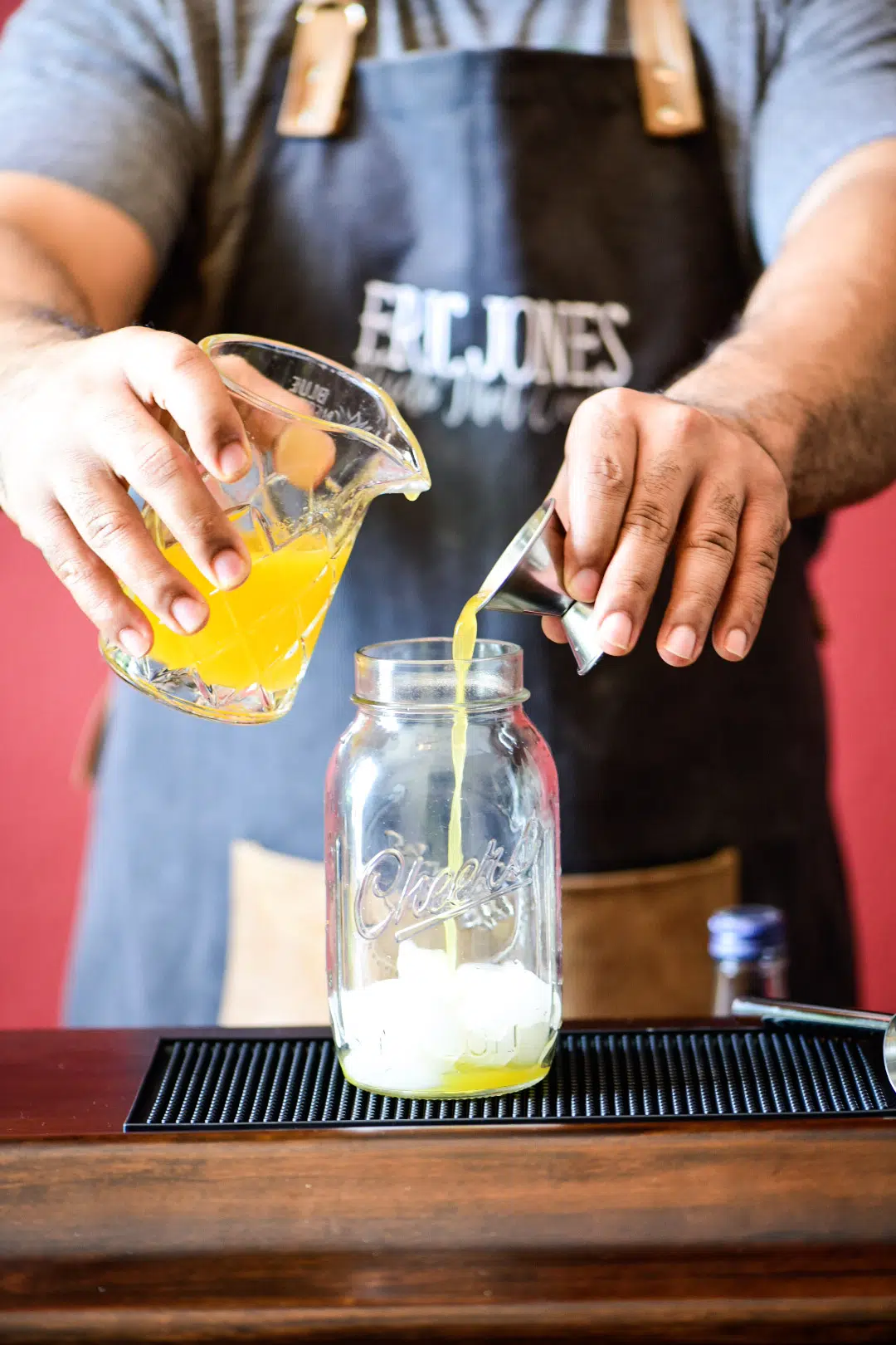Adding fresh mandarin juice to cocktail shaker for Mandarin Orange Crush Cocktail
