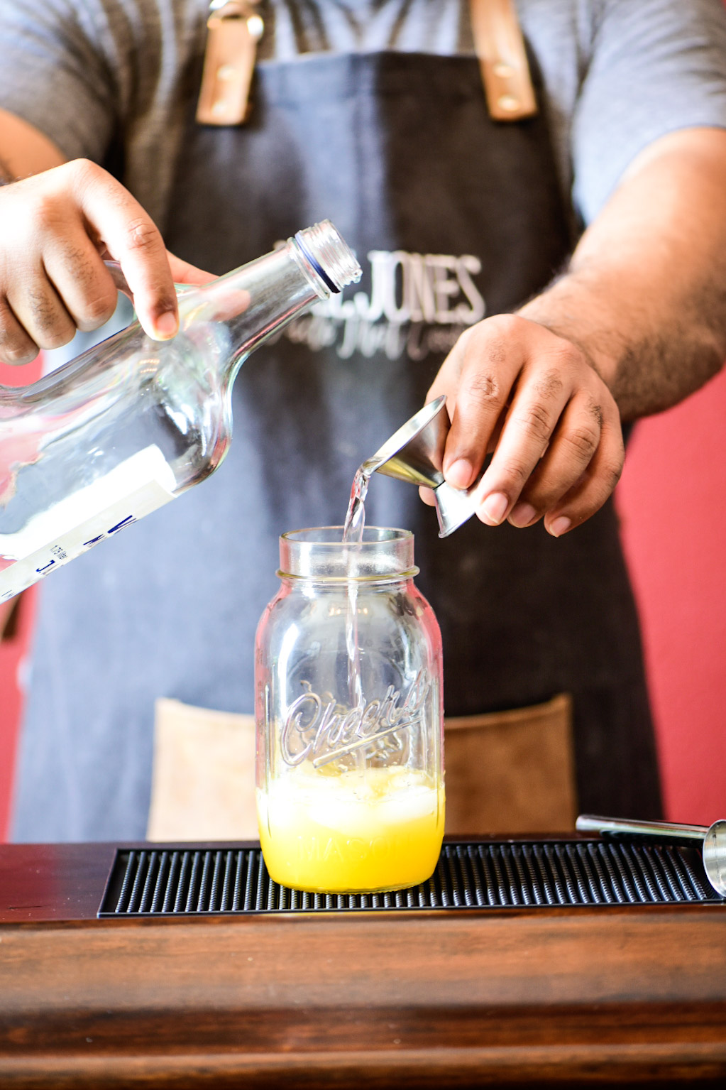 Adding vodka to cocktail shaker for Mandarin Orange Crush Cocktail