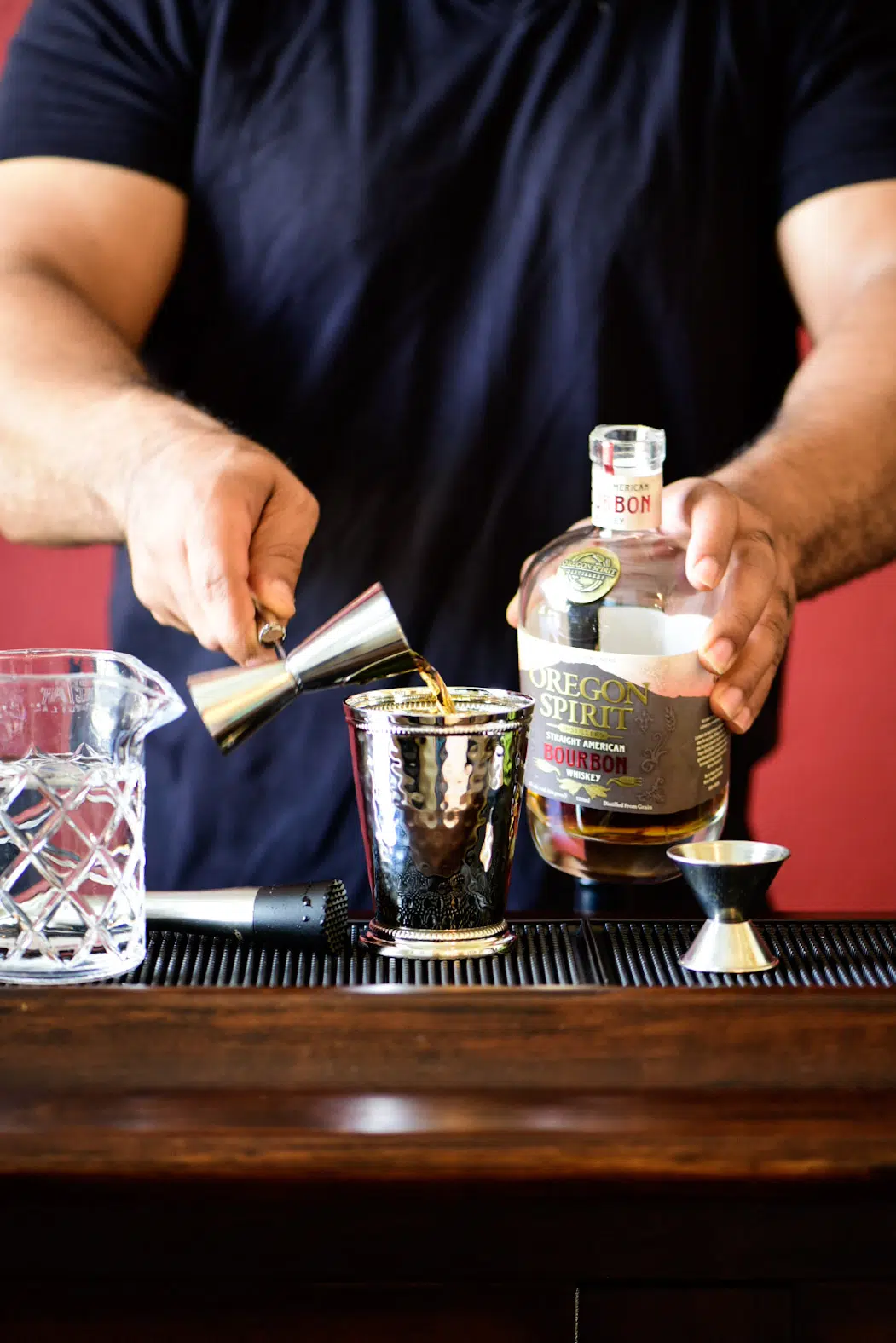 Pouring bourbon into mint julep cup