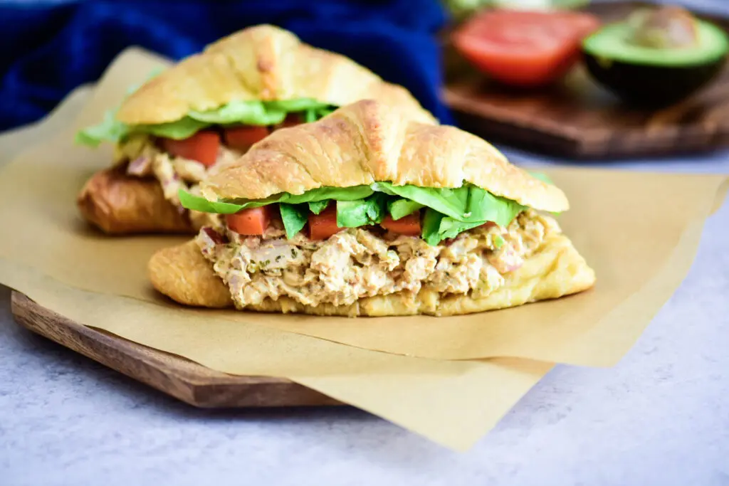 Chicken salad sandwich on a croissant with butter lettuce and tomato