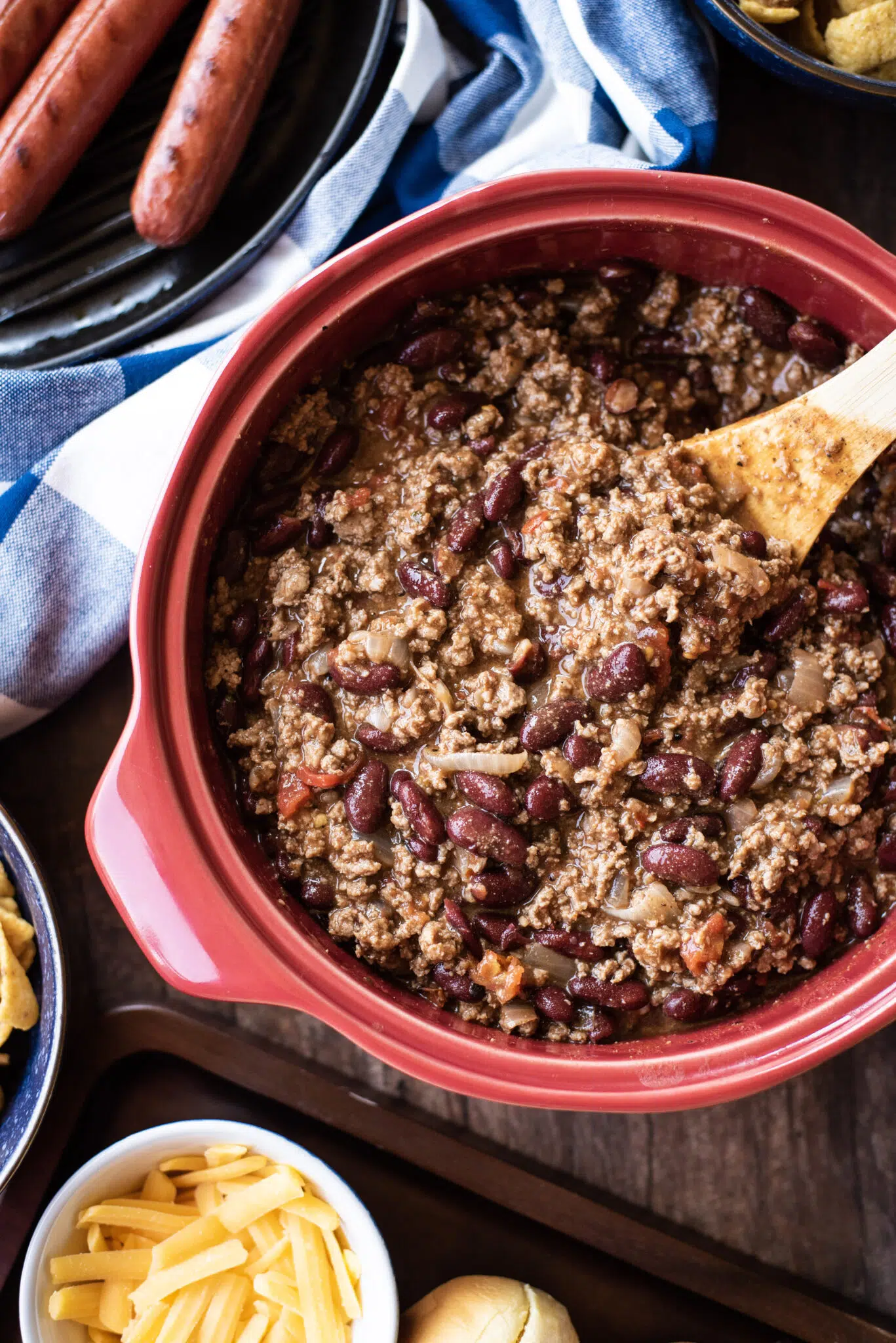 Overhead shot of chili with wooden spoon to serve