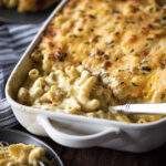 Baked macaroni and cheese being served from casserole