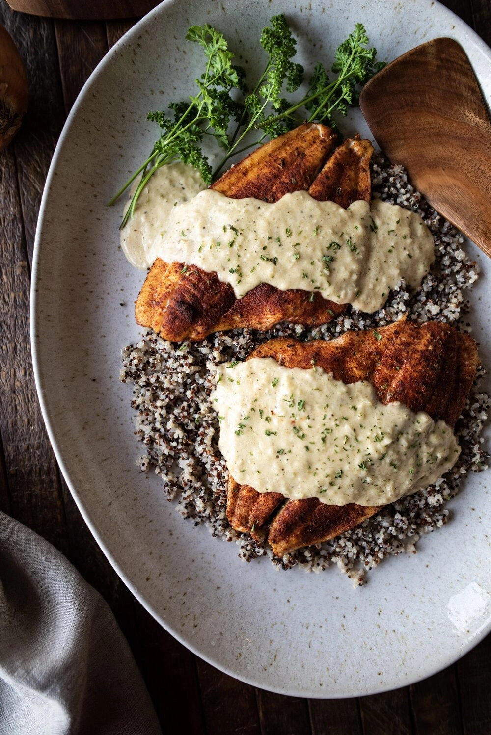 Overhead shot of baked flounder and pontchartrain sauce over quinoa