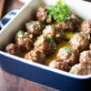 Close up shot of deep casserole dish of meatballs