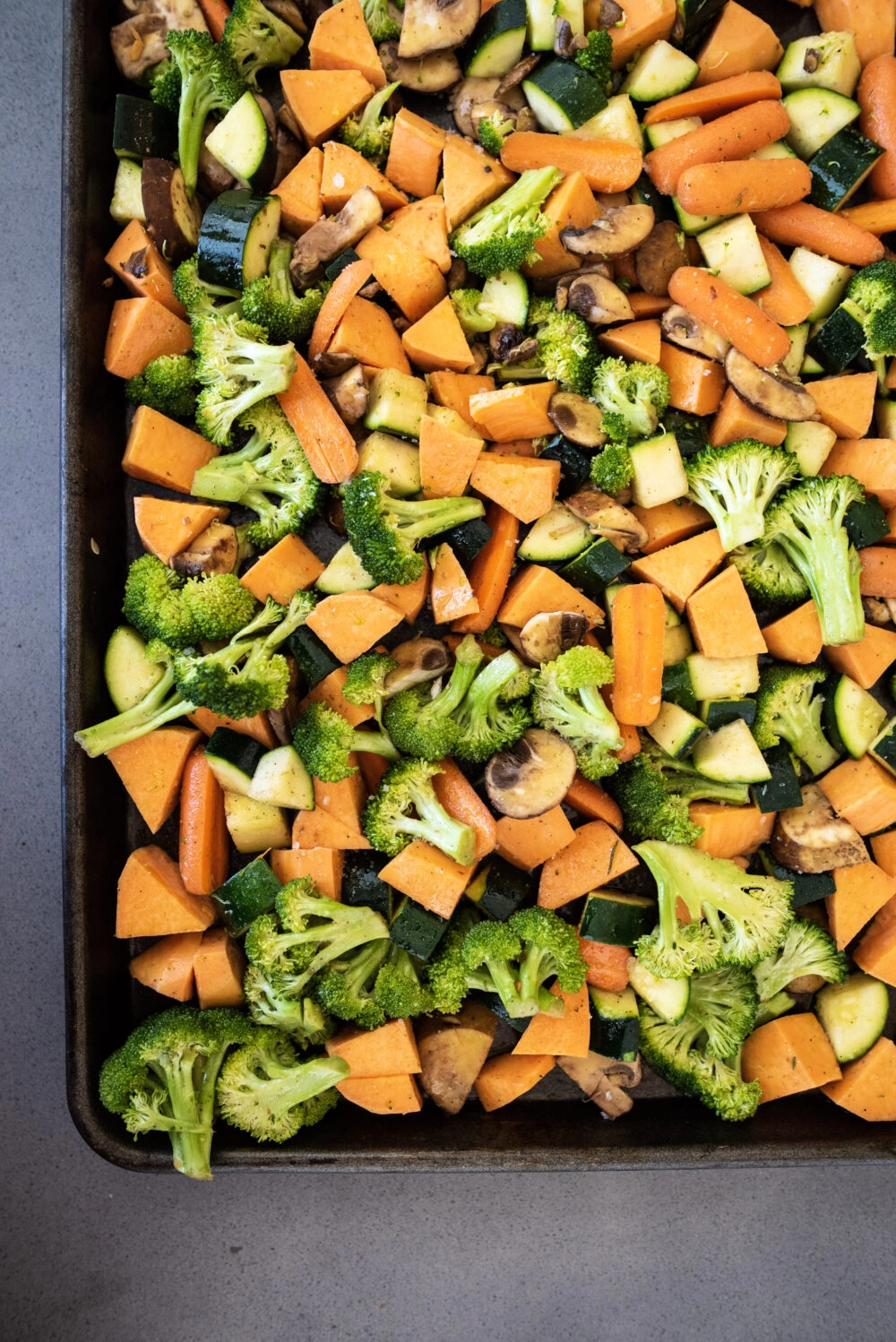 raw vegetables including carrots, mushrooms, sweet potatoes, and zucchini