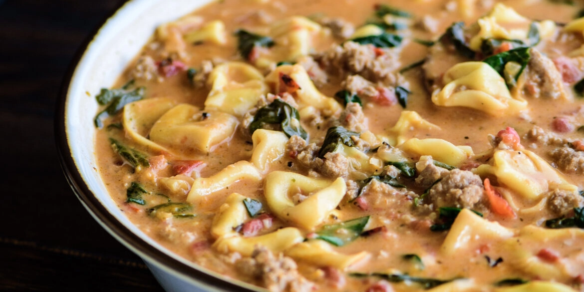creamy tortellini soup in a large serving bowl