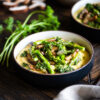 cheesy polenta and spring veggies surrounded by fresh mushrooms, asparagus, and parsley