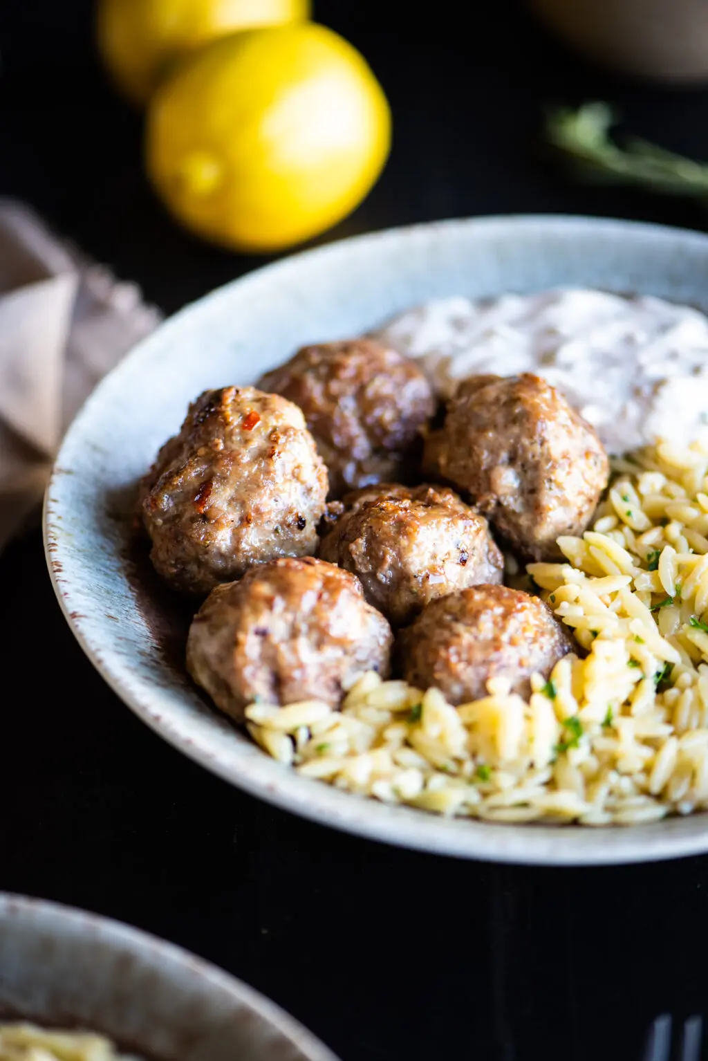 Lamb meatballs with lemons in the background