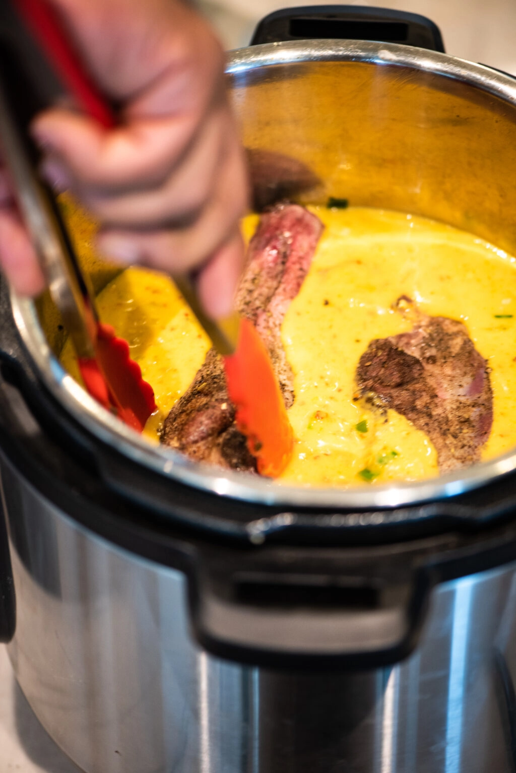 placing seared lamb shanks in curry sauce