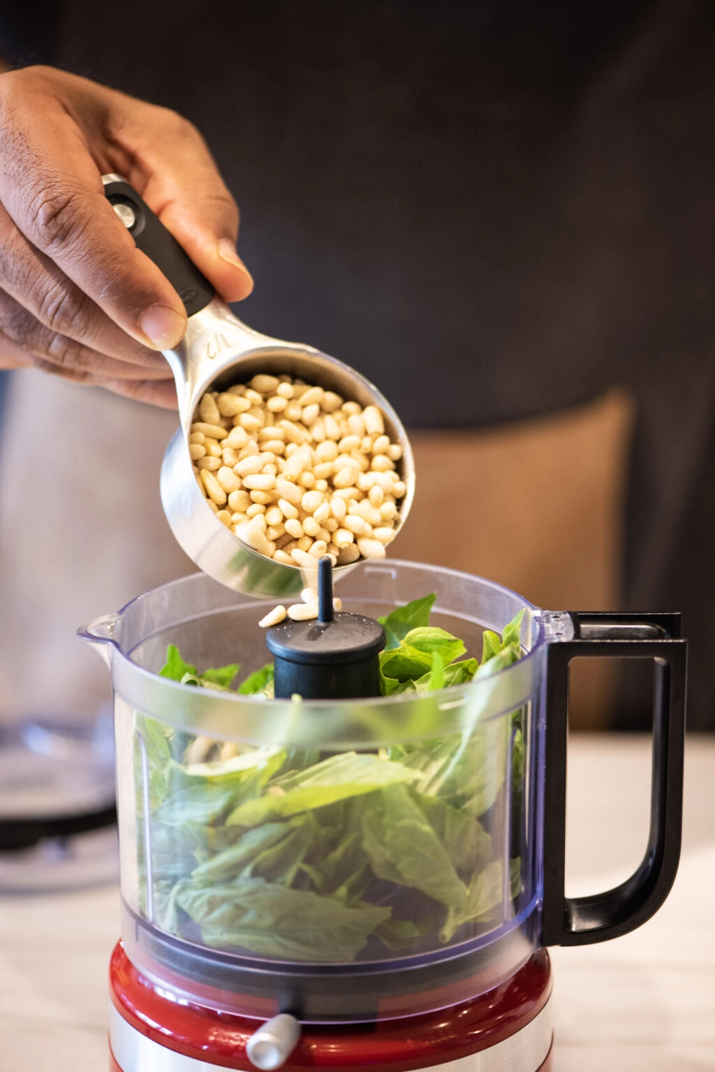 Adding pine nuts to food processor 