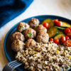 Plate of cajun meatballs, dirty rice, and a cucumber salad for meal prep