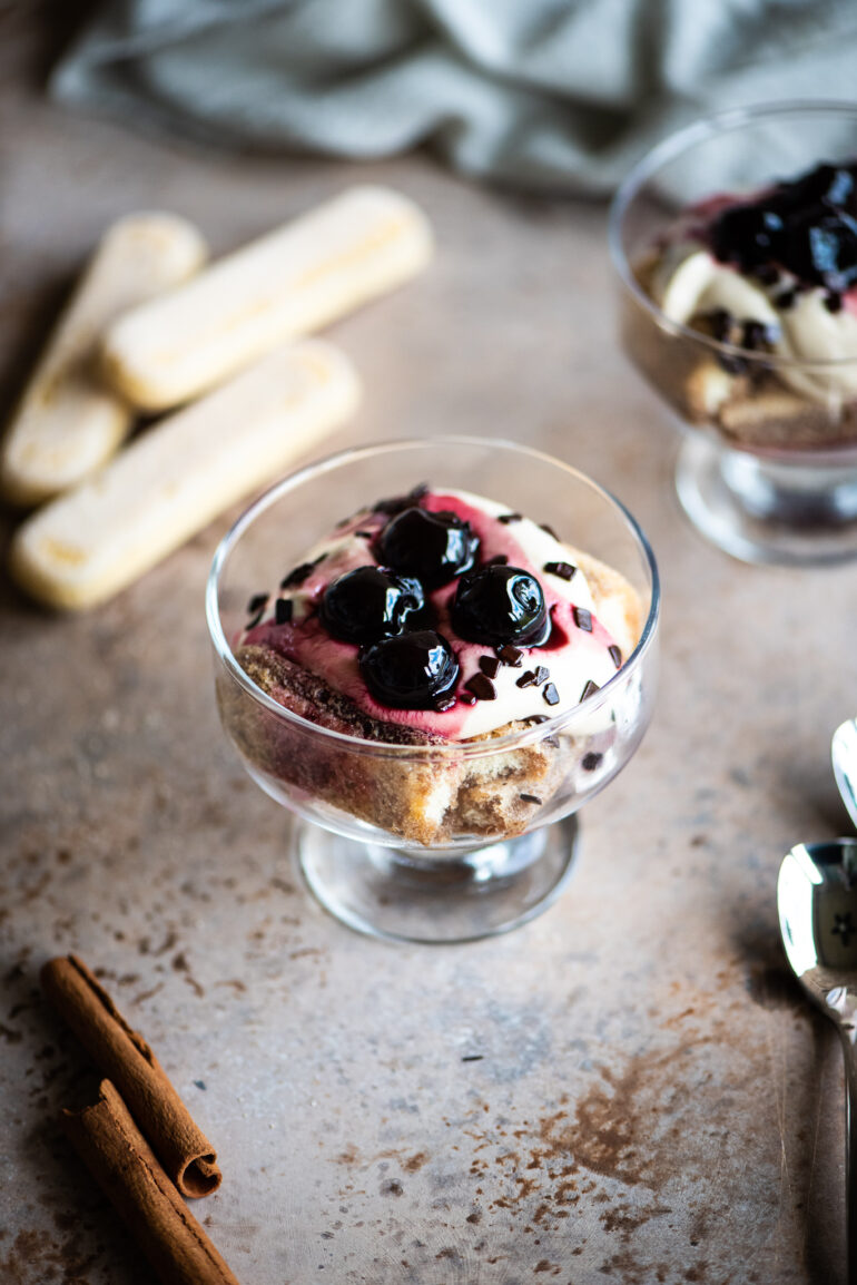 deconstructed tiramisu with cherries and chocolate served in a small glass bowl