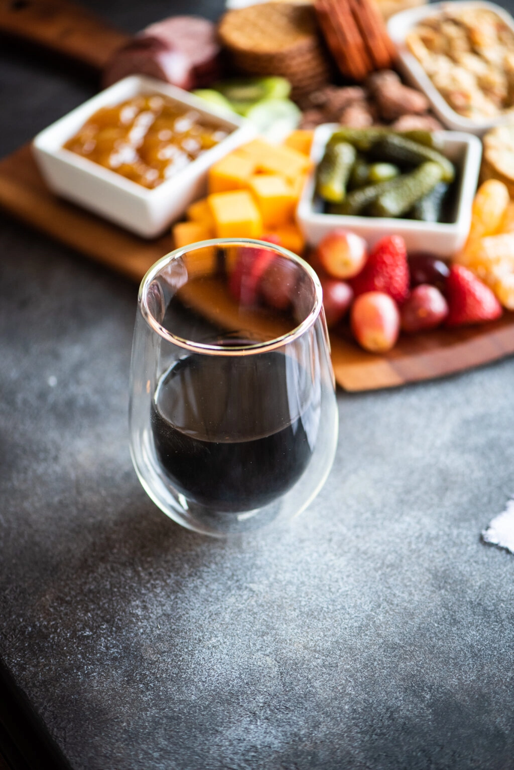 Red wine in a glass with a charcuterie board