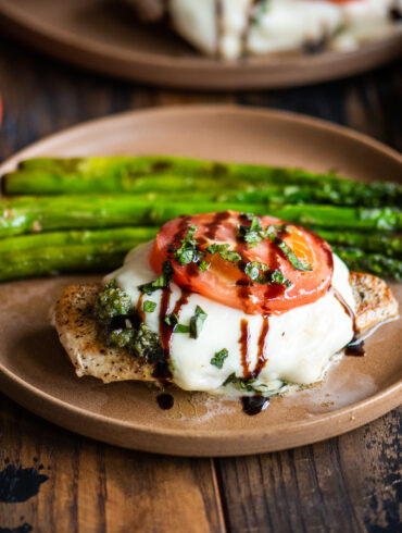 Chicken caprese served with asparagus
