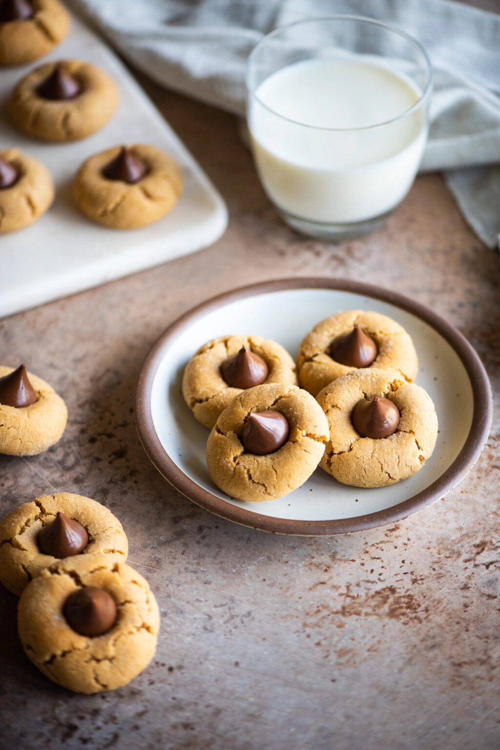 peanut butter blossom cookies served on a plate with a cup of milk
