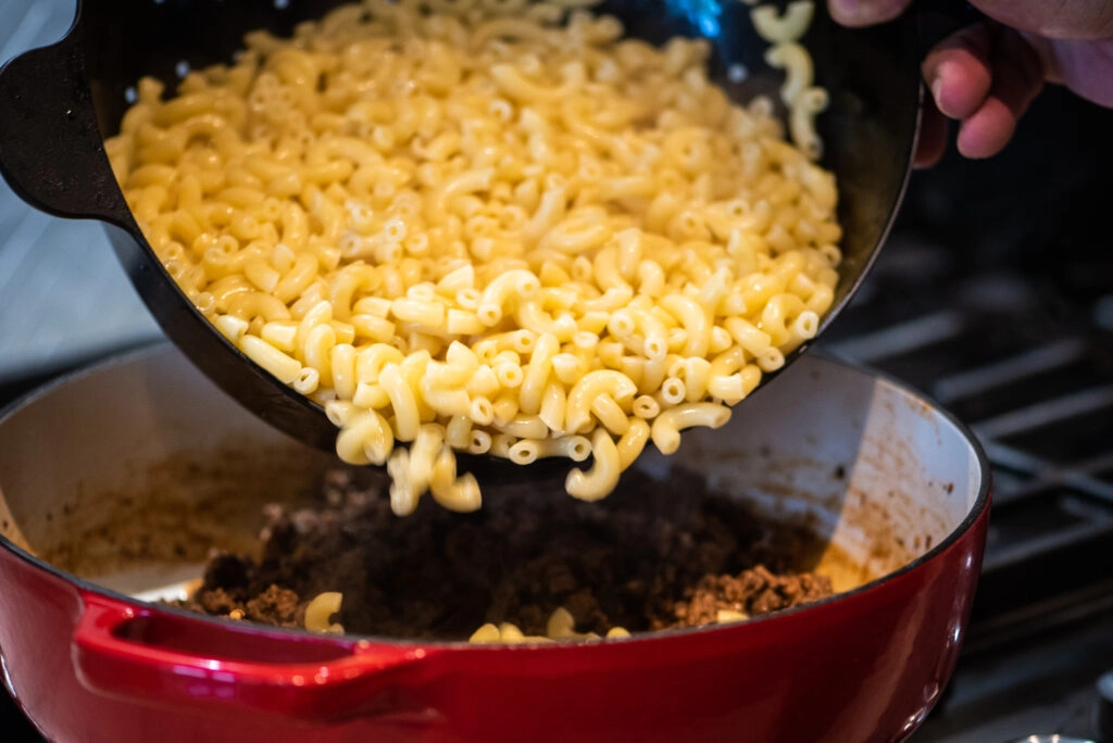 adding cooked pasta to pan