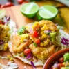 single crispy fish taco topped with corn salsa