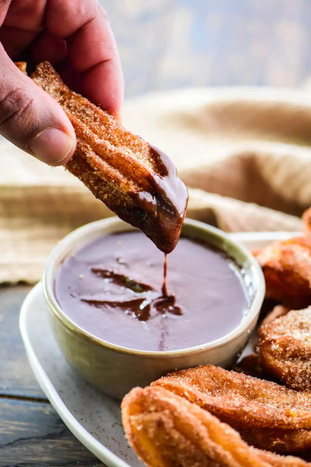 dipping churro in chocolate sauce