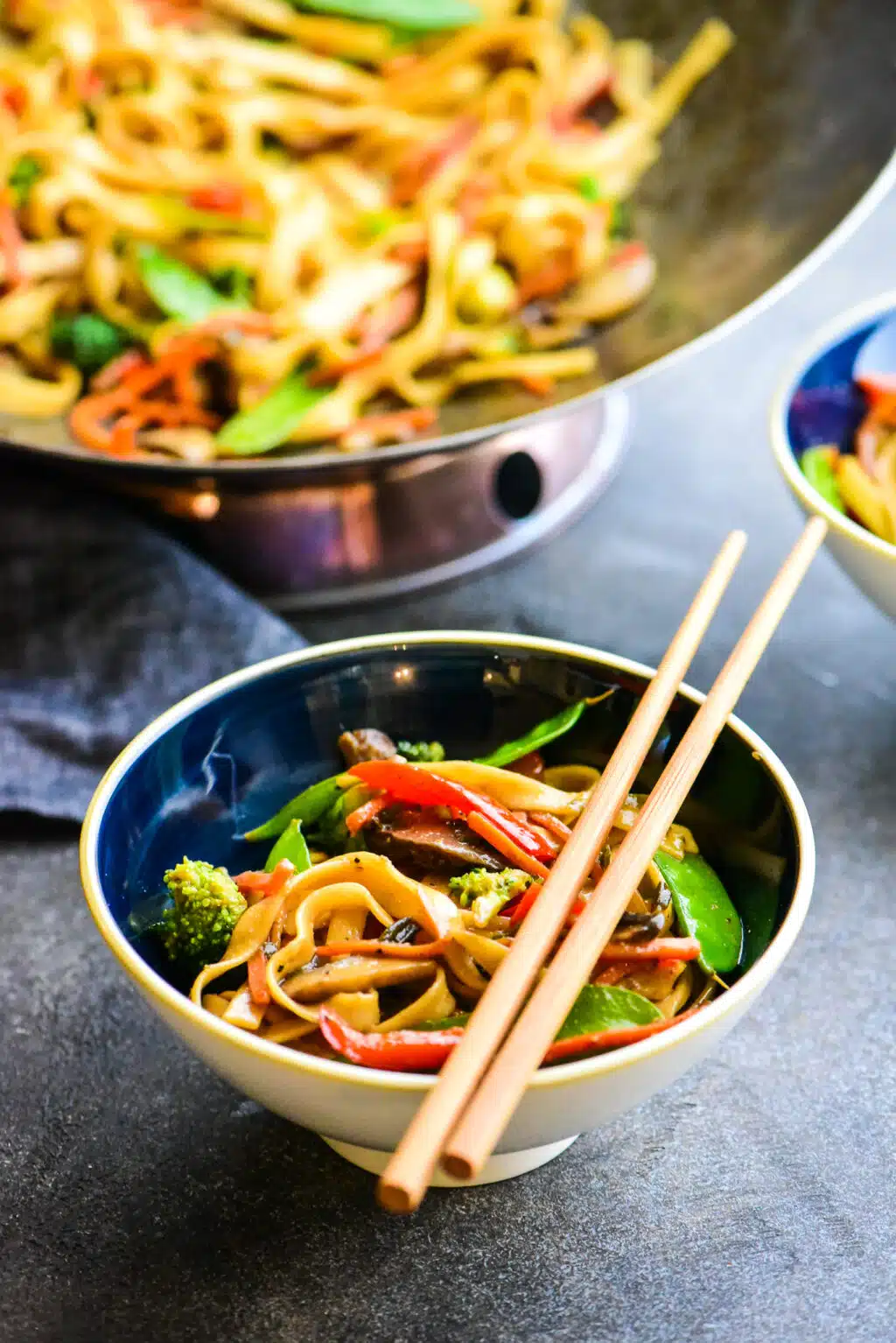 serving of vegetable stir fry noodles in a bowl with chopsticks