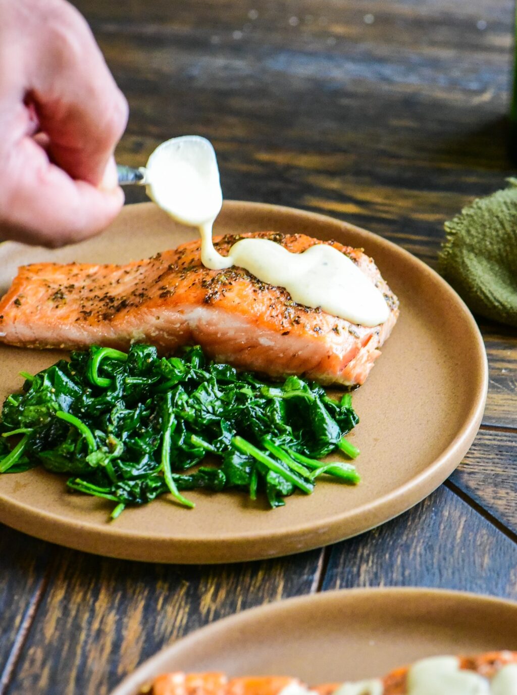 drizzling creamy mustard sauce over pan seared salmon