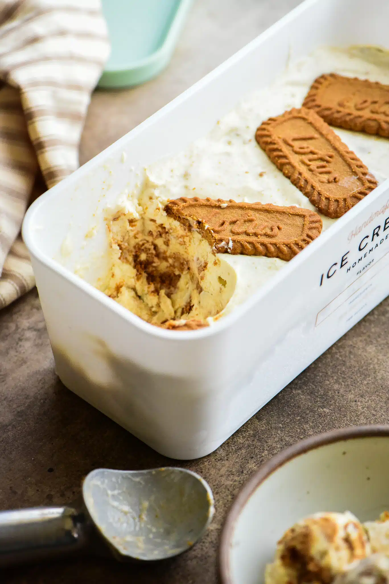no-churn Biscoff ice cream in a freezer-safe storage tub. with a scoop taken out